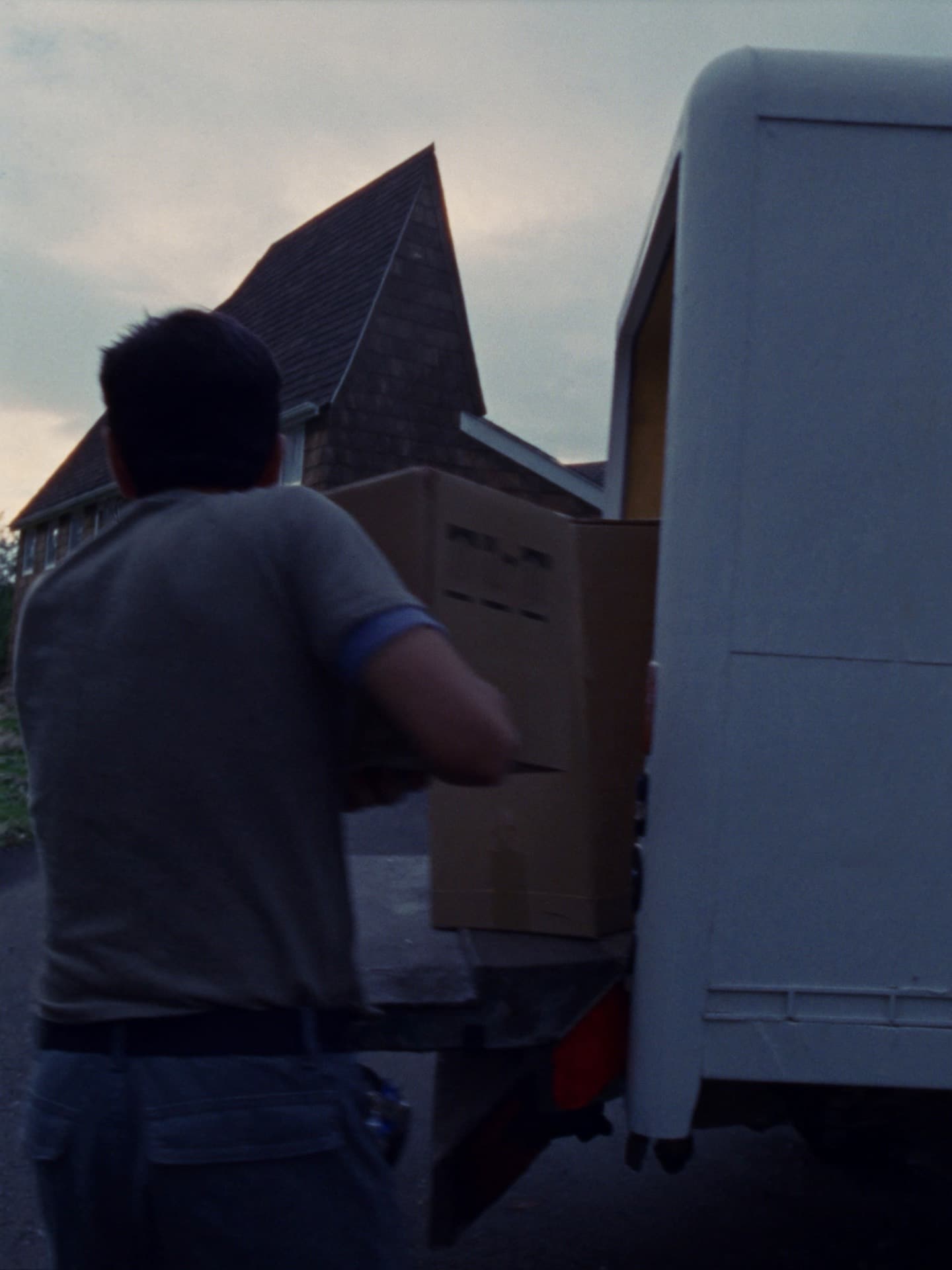 A Mazheika crew member loading a box into the truck at dusk